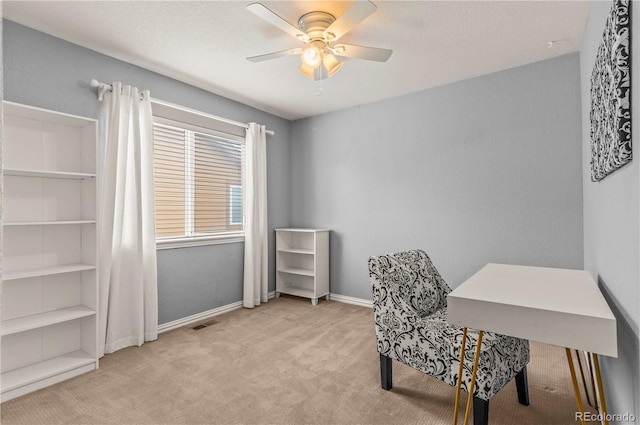 carpeted home office with a ceiling fan and baseboards