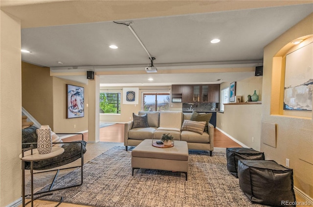 living room featuring recessed lighting, baseboards, and stairway