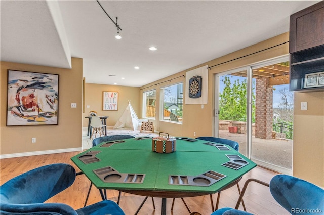 playroom with wood finished floors, recessed lighting, baseboards, and rail lighting