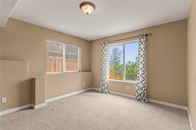 carpeted spare room featuring baseboards