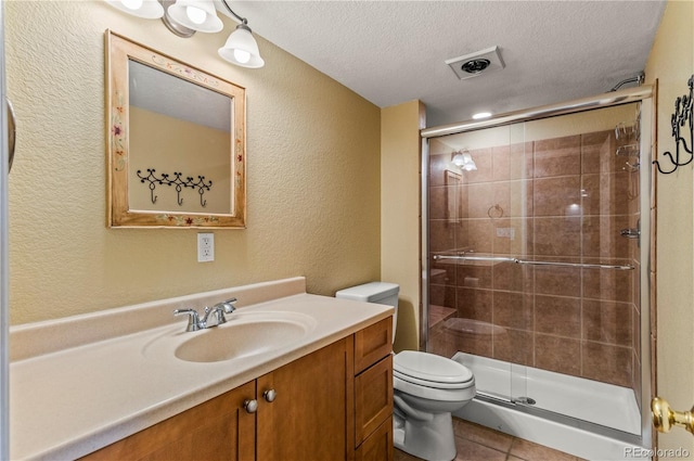 full bath with a textured wall, a textured ceiling, toilet, a shower stall, and vanity