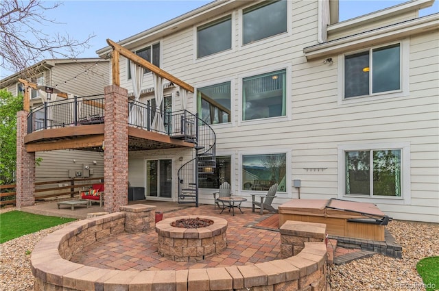 rear view of house featuring a fire pit, stairway, a patio, a wooden deck, and a hot tub