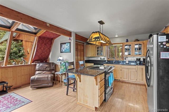 12191 Tecumseh Trl, Conifer, CO 80433 - kitchen featuring appliances with stainless steel finishes, light wood-style floors, a sink, a kitchen bar, and a kitchen island