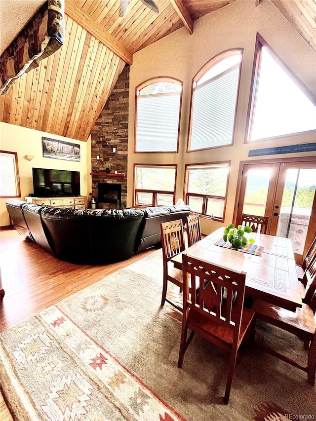12191 Tecumseh Trl, Conifer, CO 80433 - dining area featuring high vaulted ceiling, wooden ceiling with exposed beams, wood finished floors, and a large fireplace
