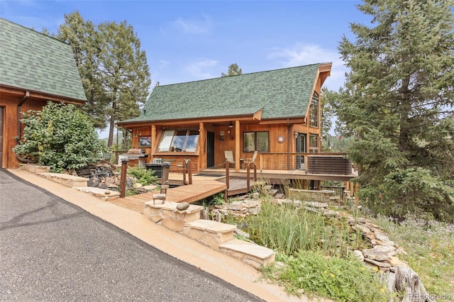 12191 Tecumseh Trl, Conifer, CO 80433 - chalet / cabin featuring roof with shingles, a wooden deck, and central air condition unit