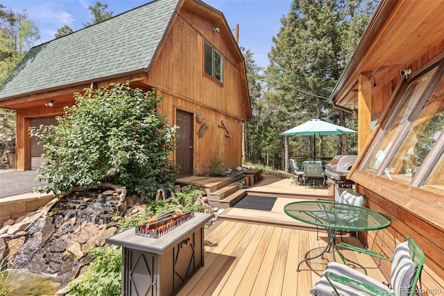 12191 Tecumseh Trl, Conifer, CO 80433 - deck with a fire pit, outdoor dining area, a grill, and a garage