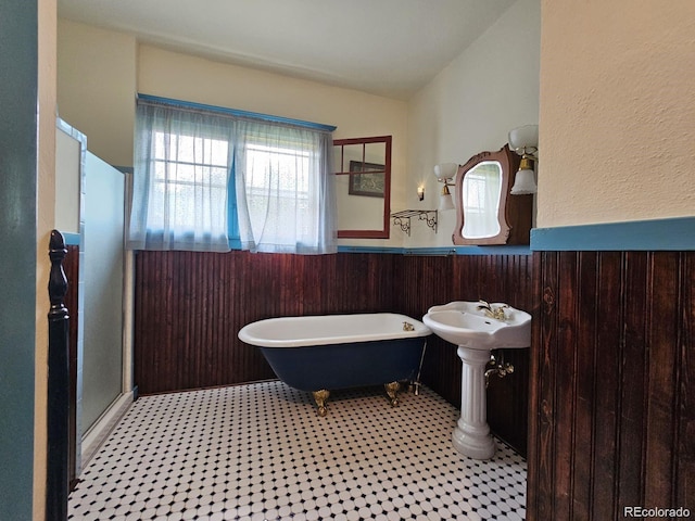 243 Park Ave, Salida, CO 81201 - bathroom with wainscoting, a freestanding bath, tile patterned floors, a stall shower, and wood walls