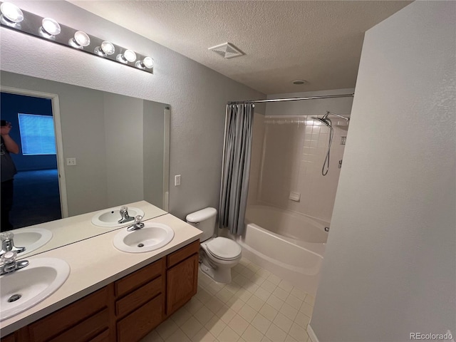 full bathroom featuring vanity, toilet, a textured ceiling, and shower / tub combo