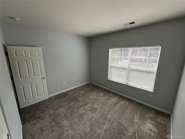 empty room featuring dark colored carpet