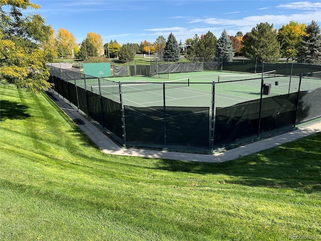 view of tennis court featuring a yard