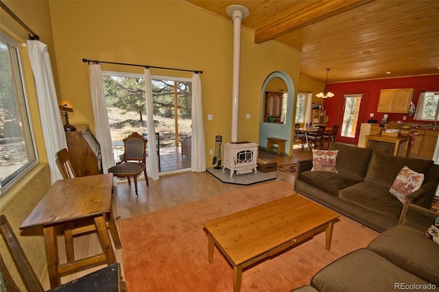 3713 Enchanted Way, Crestone, CO 81131 - living room with a wood stove, beam ceiling, wooden ceiling, a notable chandelier, and light wood-style flooring
