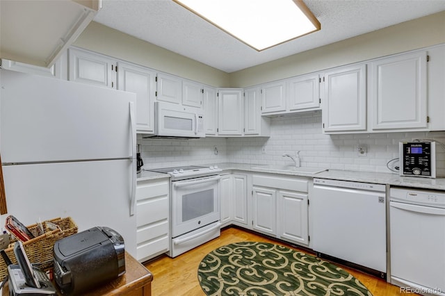 12565 Sheridan Blvd Unit 105, Broomfield, CO 80020 - kitchen featuring white appliances, a sink, white cabinets, and backsplash