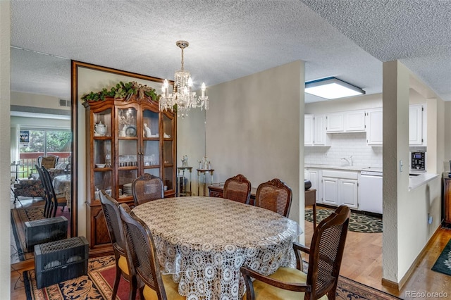12565 Sheridan Blvd Unit 105, Broomfield, CO 80020 - dining space featuring a chandelier, wood finished floors, and a textured ceiling