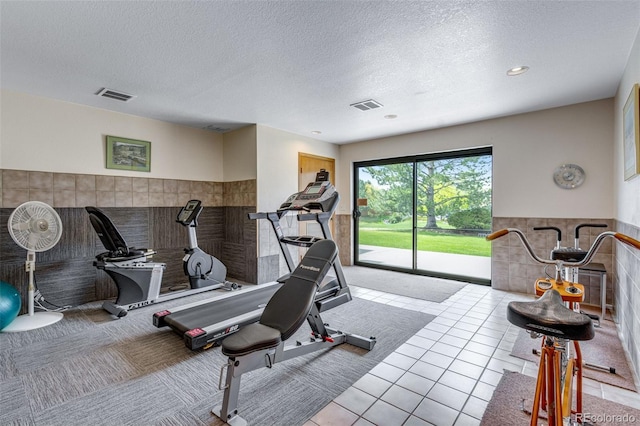 12565 Sheridan Blvd Unit 105, Broomfield, CO 80020 - exercise area featuring a textured ceiling, carpet, tile walls, recessed lighting, and tile patterned floors