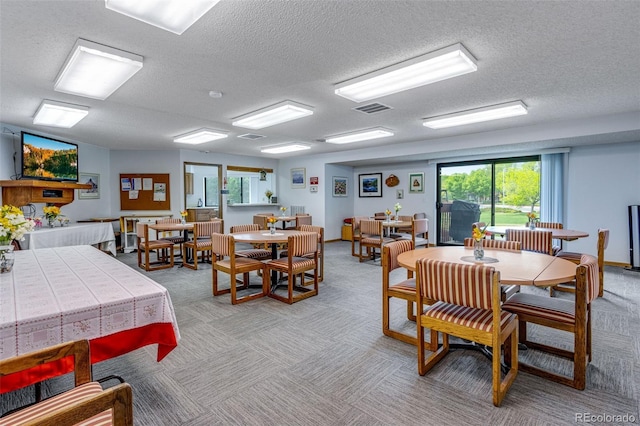 12565 Sheridan Blvd Unit 105, Broomfield, CO 80020 - dining area featuring light carpet, a textured ceiling, and healthy amount of natural light