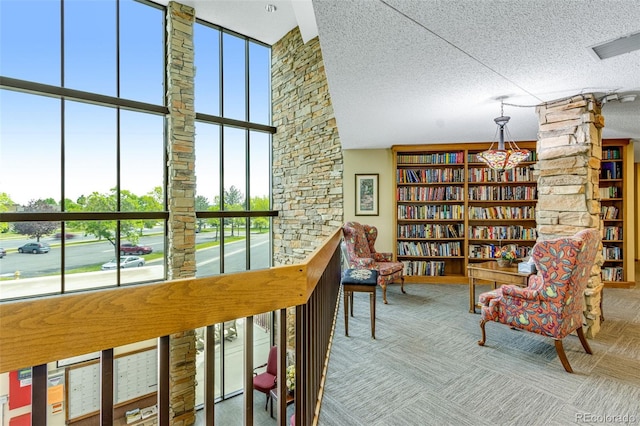 12565 Sheridan Blvd Unit 105, Broomfield, CO 80020 - sitting room with a textured ceiling, a high ceiling, and decorative columns