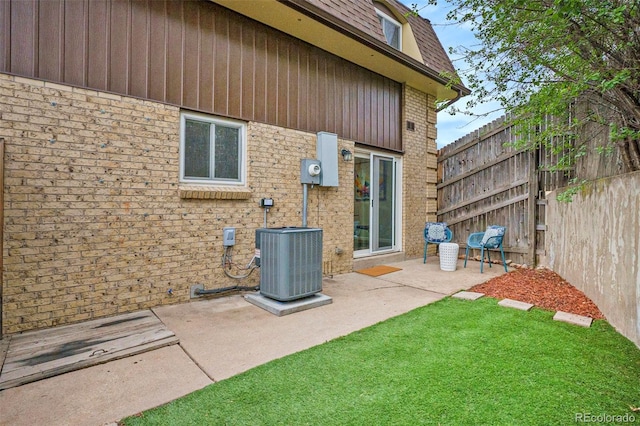 5573 S Lowell Blvd, Littleton, CO 80123 - rear view of property featuring central air condition unit, a patio, brick siding, and roof with shingles