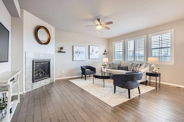 8695 Torrey St, Arvada, CO 80007 - living room featuring ceiling fan, dark wood-style flooring, a fireplace, and baseboards