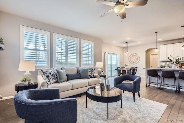 8695 Torrey St, Arvada, CO 80007 - living area featuring wood-type flooring, a ceiling fan, recessed lighting, baseboards, and arched walkways