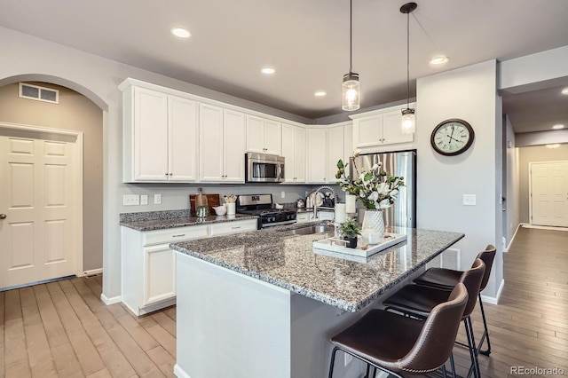 8695 Torrey St, Arvada, CO 80007 - kitchen featuring appliances with stainless steel finishes, a sink, arched walkways, baseboards, and recessed lighting