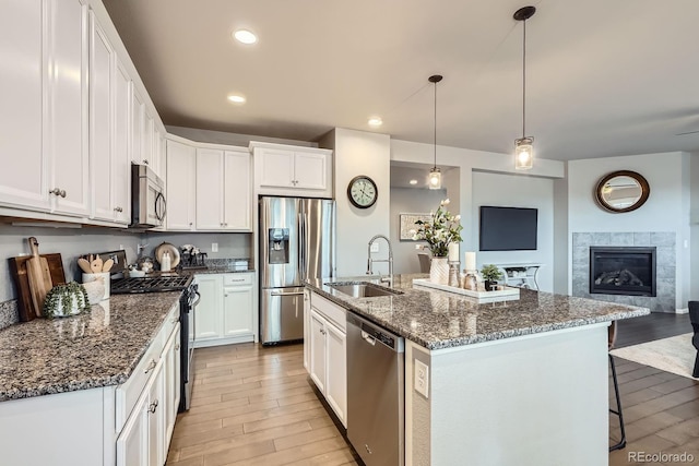 8695 Torrey St, Arvada, CO 80007 - kitchen featuring appliances with stainless steel finishes, a sink, light wood-style flooring, white cabinets, and recessed lighting