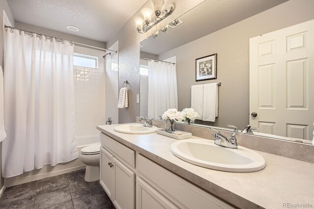 8695 Torrey St, Arvada, CO 80007 - full bath with toilet, double vanity, and shower / bathtub combination with curtain