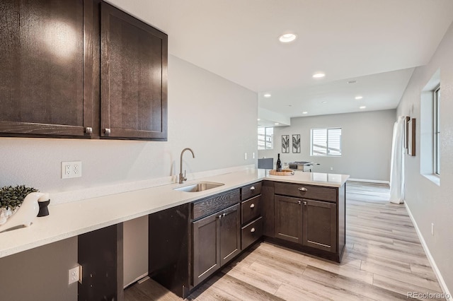 8695 Torrey St, Arvada, CO 80007 - kitchen with a sink, dark brown cabinets, light countertops, light wood-style floors, and recessed lighting