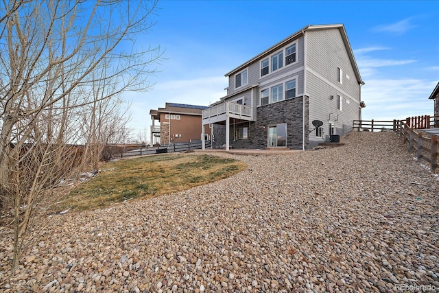 8695 Torrey St, Arvada, CO 80007 - rear view of property with stone siding, a fenced backyard, a patio area, and a deck
