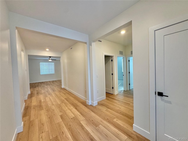 hall featuring light wood-style floors and baseboards