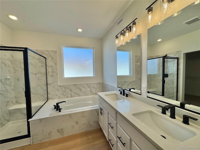 bathroom with visible vents, a garden tub, a sink, and a marble finish shower