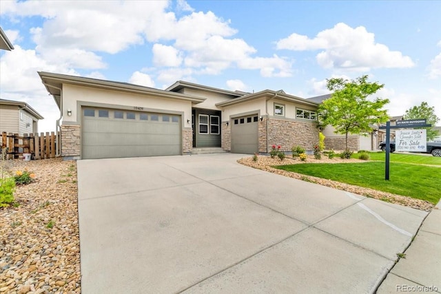 19409 W 88th Dr, Arvada, CO 80007 - prairie-style house with stone siding, stucco siding, a garage, and driveway