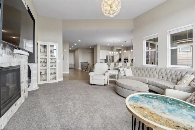 19409 W 88th Dr, Arvada, CO 80007 - carpeted living room with a chandelier, a fireplace, baseboards, built in shelves, and recessed lighting