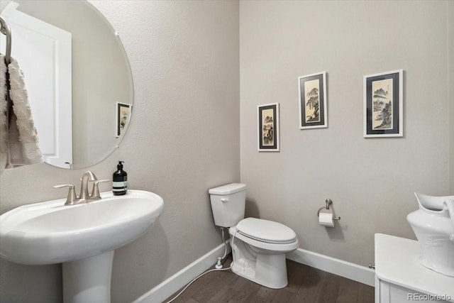 19409 W 88th Dr, Arvada, CO 80007 - half bath with toilet, baseboards, wood finished floors, and a sink