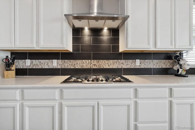 19409 W 88th Dr, Arvada, CO 80007 - kitchen featuring wall chimney range hood, stainless steel gas cooktop, white cabinets, and backsplash