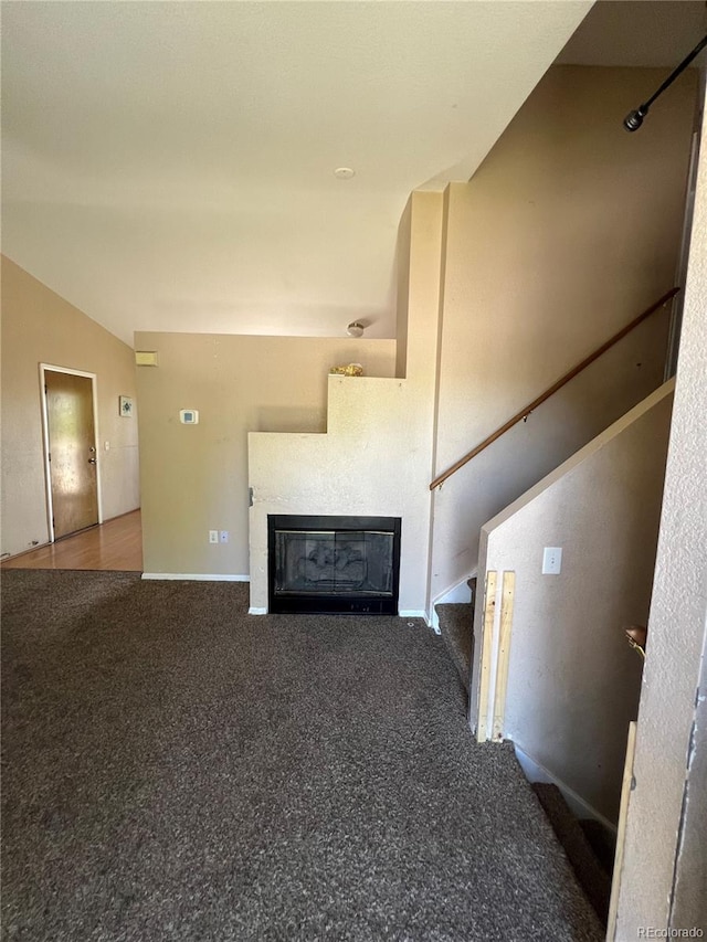 unfurnished living room with lofted ceiling and carpet flooring