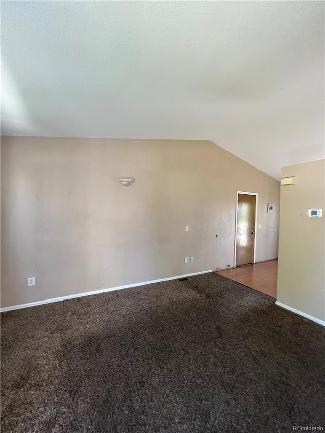 spare room featuring lofted ceiling and carpet floors