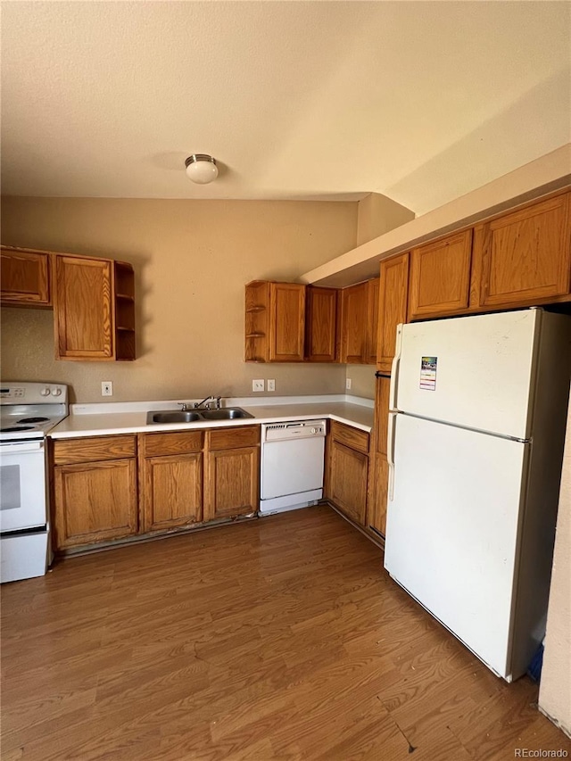 kitchen featuring lofted ceiling, sink, white appliances, and dark wood-type flooring