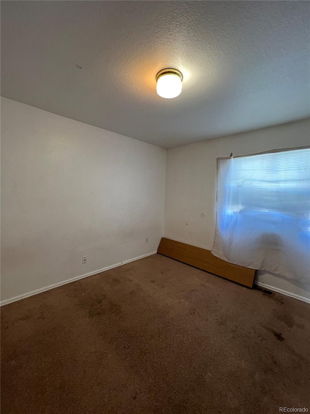 carpeted spare room featuring a textured ceiling