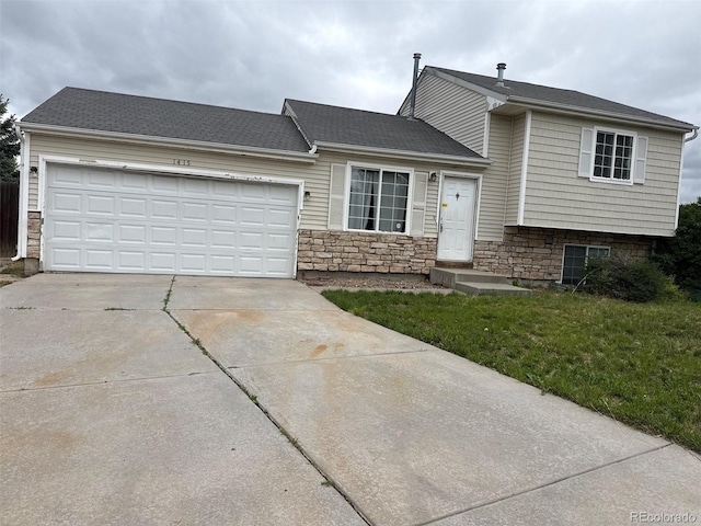 1415 S Pitkin Ct, Aurora, CO 80017 - tri-level home featuring concrete driveway, a garage, a front yard, and stone siding