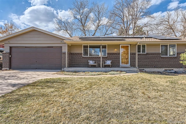 ranch-style home featuring brick siding, a front yard, covered porch, a garage, and driveway