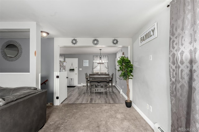 117 6th St, Frederick, CO 80530 - carpeted living room featuring baseboard heating, a chandelier, a baseboard heating unit, and baseboards