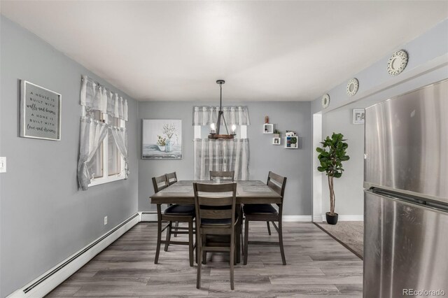 117 6th St, Frederick, CO 80530 - dining room with a baseboard heating unit, wood finished floors, and baseboards