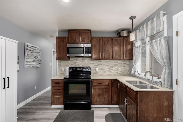 117 6th St, Frederick, CO 80530 - kitchen featuring stainless steel microwave, black electric range oven, a sink, and light countertops