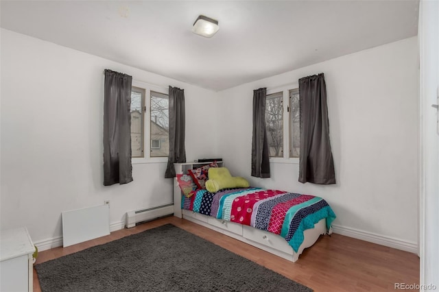117 6th St, Frederick, CO 80530 - bedroom featuring a baseboard radiator, wood finished floors, and baseboards