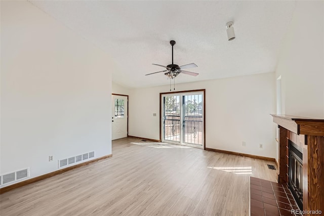 unfurnished living room featuring a fireplace, a textured ceiling, hardwood / wood-style flooring, and ceiling fan