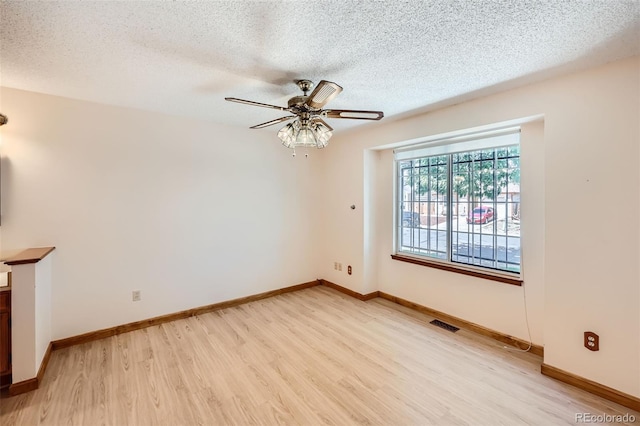 unfurnished room with a textured ceiling, ceiling fan, and light hardwood / wood-style floors