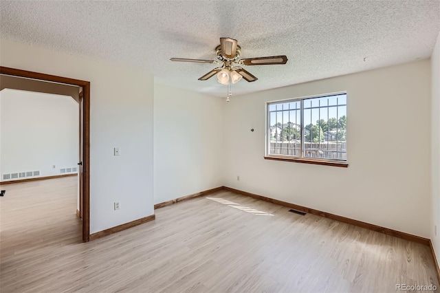 spare room with a textured ceiling, ceiling fan, and light wood-type flooring