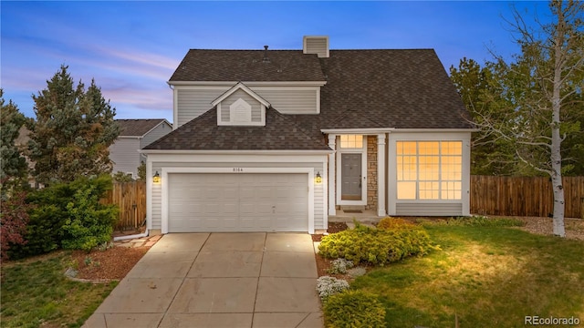 traditional-style house featuring a shingled roof, driveway, a garage, and a chimney