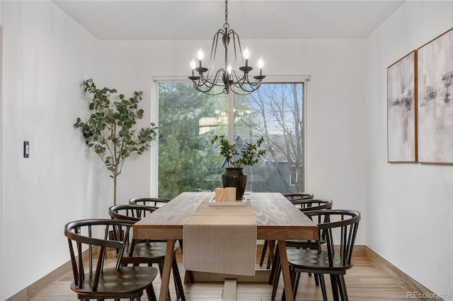 dining area featuring a chandelier, plenty of natural light, light wood-type flooring, and baseboards