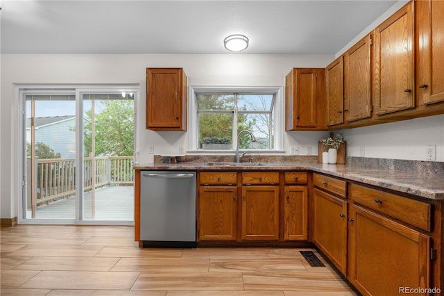 kitchen featuring dishwasher, a sink, and brown cabinets